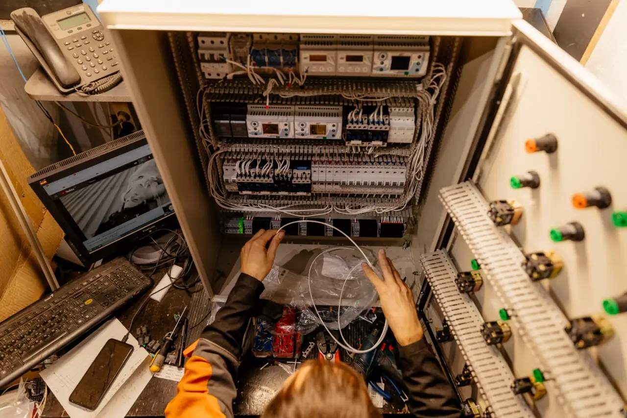 Monteur werkt aan een elektrische installatie in een bedieningsruimte