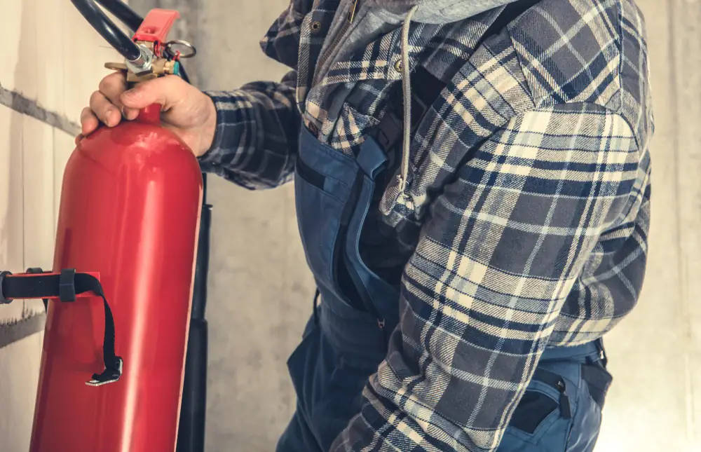 Persoon controleert de bediening van een brandblusser