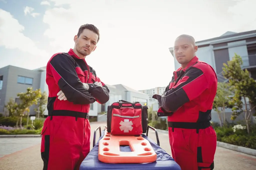 Twee hulpverleners met een AED en EHBO-materiaal